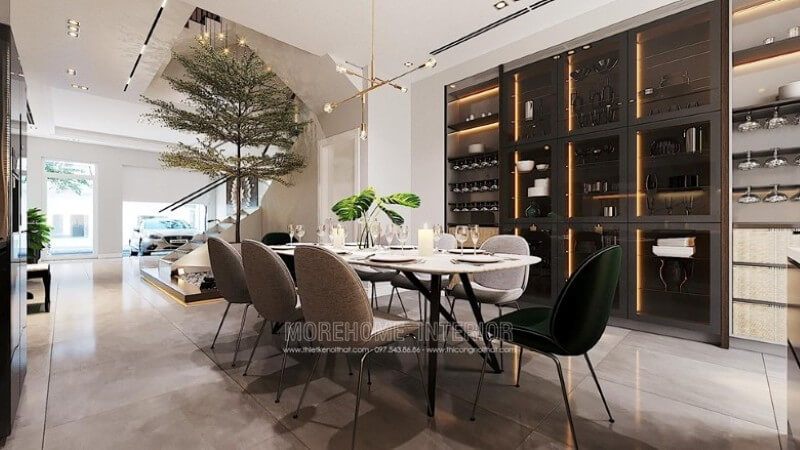 Phòng ăn được trang trí đẹp với bộ bàn ăn dành cho 8 thành viên, đèn thả trần nghệ thuật, gạch lát nền giả đá màu nâu cao cấp và tủ gỗ kết hợp kính có đèn led để hiển thị đồ hiện đại.